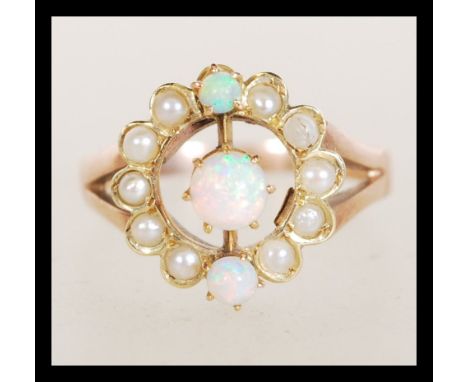 An early 20th Century 9ct gold ring set with a round opal with two smaller accent opals and a halo of seed pearls. Total weig