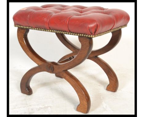 A 20th Century Georgian revival red leather button back padded footstool of&nbsp;Glastonbury form, raised on mahogany cross s