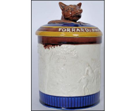 A 19th century Wedgwood majolica tobacco jar having a fox finial to the lid with inscription 'Tally Ho, Forrard Away', having