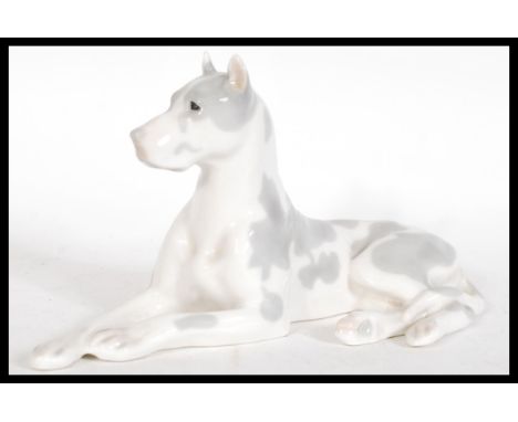 A vintage 20th Century USSR ceramic figurine of a great dane modelled in a reclined position but remaining alert. Stamped to 