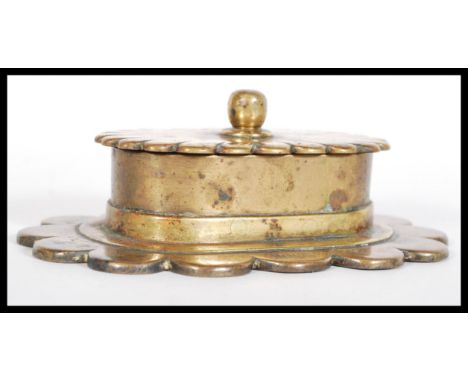 An early 20th Century bronze desk paperweight snuff box raised on a scalloped base with hinged lid and finial top. Stamped WW