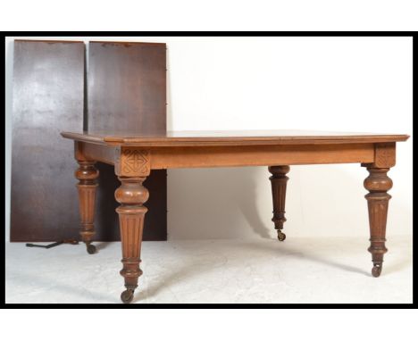 A Victorian oak extending dining table, the rectangular surface with canted corners,&nbsp;raised on turned and carved baluste