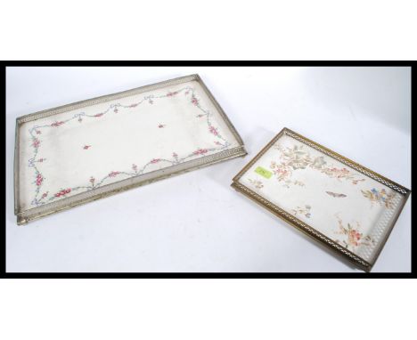 Two 20th Century decorative trays having ceramic bases with floral decoration and pierced decoration metal edging, raised on 