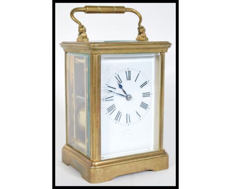 An early 20th Century French brass cased carriage clock having bevelled glass panels. The white enamel face having Roman nume