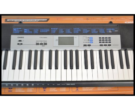 A boxed Casio CTK - 1550 electronic keyboard / organ together with the keyboard stand also retaining original box.