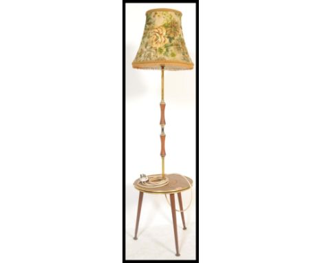 A vintage mid Century floor standing standard lamp, raised on three tapering supports with a drinks tray atop, central column