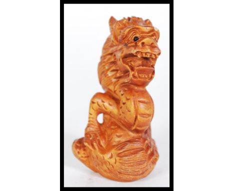 A 20th Century carved Japanese netsuke in the form of a dragon being signed to base. Measures 6 cm high.