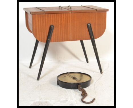 A mid 20th Century sewing box raised on four tapering legs with a twin doors to the top with metal handles along with a set o
