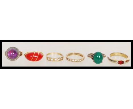 A group of six vintage rings&nbsp; to include a hallmarked 9ct gold three stone CZ ring, a 9ct gold eternity ring. two silver