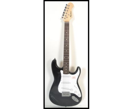 A vintage Rockburn electric six string guitar. The black body having white scratch guard with chrome tuning pegs and mother o