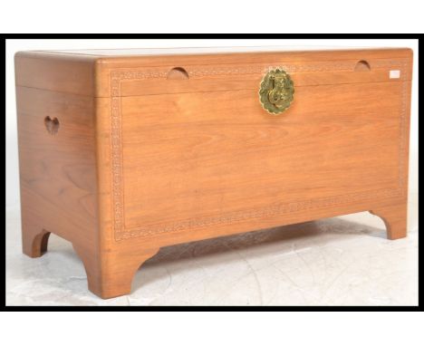 A 20th Century large chamfer wood blanket box storage chest trunk coffer having carved detailing and inset handles. The hinge