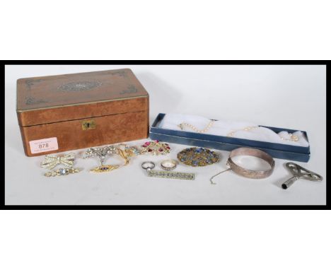 A selection of vintage costume jewellery to include a round filigree brooch set with blue stones, a wreath brooch set with pi