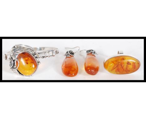A collection of sterling silver and amber effect jewellery to include a pair of large drop earrings, Art Nouveau bangle with 