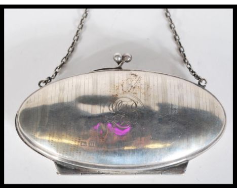 A hallmarked early 20th Century silver purse of ovoid form having engine turned band decoration and monogram to front. Set on