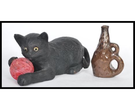 A Bretby figurine in the form of a cat with a ball of pink yarn no. 1618 and a smaller art pottery bottle with an unusual dou