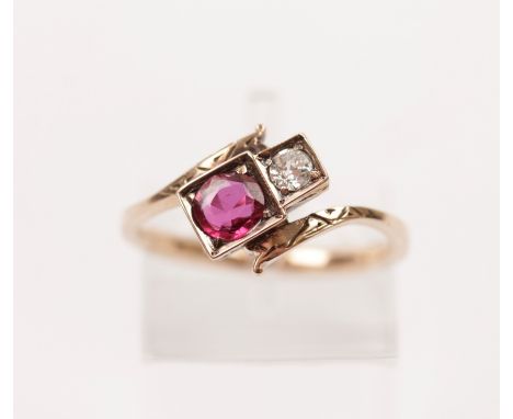 A ruby and diamond two stone ring, set with an old cut diamond, measuring approx. 0.10ct and a round cut ruby (possibly synth