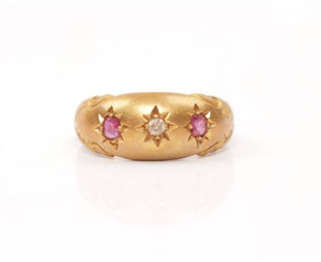 An early 20th Century hallmarked 18ct yellow gold ruby and diamond three stone ring, star set with a central round cut diamon