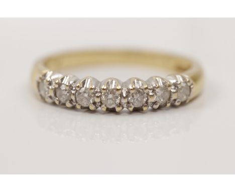 A hallmarked 18ct yellow gold seven stone diamond ring, set with seven round brilliant cut diamonds, total diamond weight app