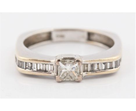 A hallmarked 18ct white gold diamond ring, set with a principal princess cut diamond measuring approx. 0.35ct, with baquette 