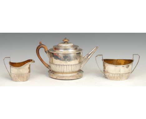 A George III silver four piece half-fluted tea service, comprising teapot, milk jug, sugar basin and teapot stand, the teapot