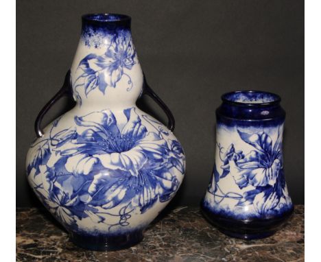 An Arts and Crafts Wileman &amp; Co. 'Faience' two-handled double gourd vase, decorated in blue with clematis, sinuous handle