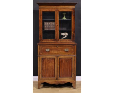 A Post-Regency mahogany secretaire bookcase, of neat proportions, outswept cornice above a pair of glazed doors enclosing two