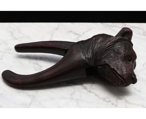 Nutcrackers - a Black Forest novelty lever-action nut cracker, carved as the head of a bear, glass eyes, 19.5cm long, c.1900 