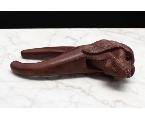 Nutcrackers - a Black Forest novelty lever-action nut cracker, carved as the head of a dog, glass eyes, 19cm long, early 20th