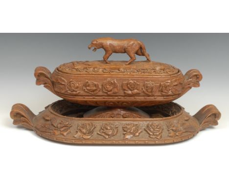 A continental carved oak table centre on stand, profusely carved with roses, the cover with large prowling cat finial, four c