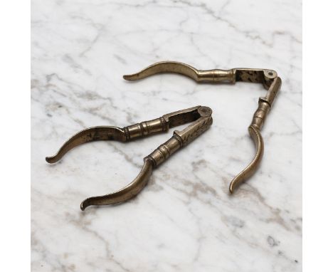 Nutcrackers - an early 18th century brass lever-action nut cracker, decorated with wrigglework, 10cm long, c.1720; another, s