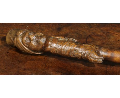 A 19th century folk art walking stick, the pommel carved with turbaned and bearded faces, 108cm long 