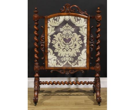 A Victorian mahogany fire screen, arched rectangular banner, spirally turned supports, cabriole legs, scroll feet, brass cast