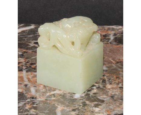 A Chinese celadon jade seal, carved with an archaic ox, 3.5cm high 