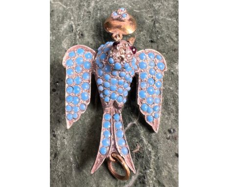 A Belle Époque unmarked dove pendant, set with an arrangement of graduated polished turquoise beads, pair of polished ruby ey