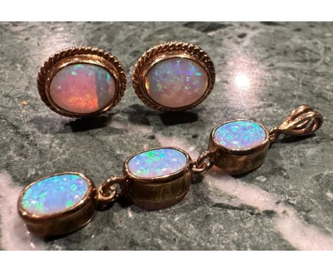 An opal pendant and earring suite, articulated oval three stone linear pendant, with strong blue green and violet colour play