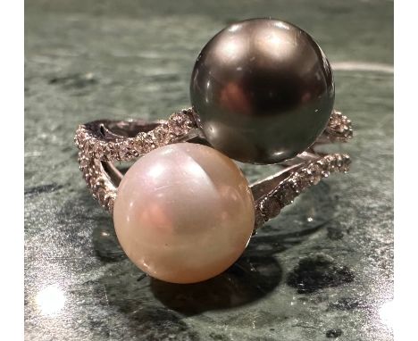 A south sea grey and creamy white cultured pearl and diamond ring, slightly twist set with large pearls measuring approx 11mm