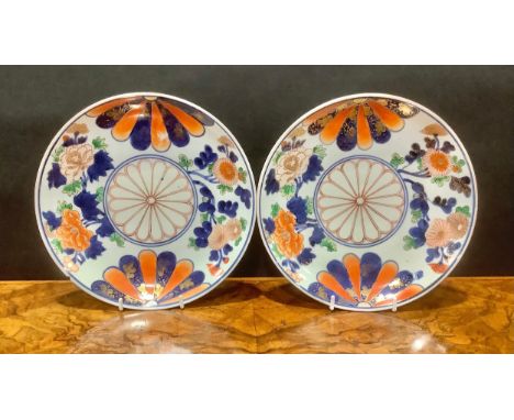 A pair of Chinese Imari circular plates, decorated with mons and flowers, picked out in gilt, 21.5cm diameter, double ring ma