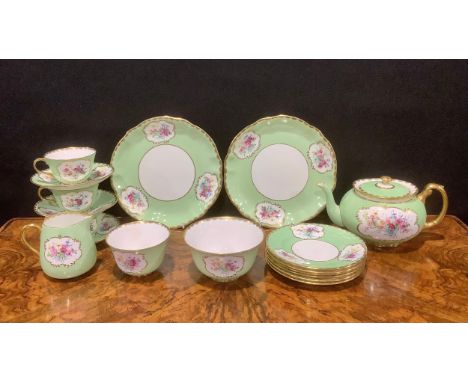 A Crown Staffordshire part tea service, painted with colourful flowers within gilt foliate borders on a pale green ground, co