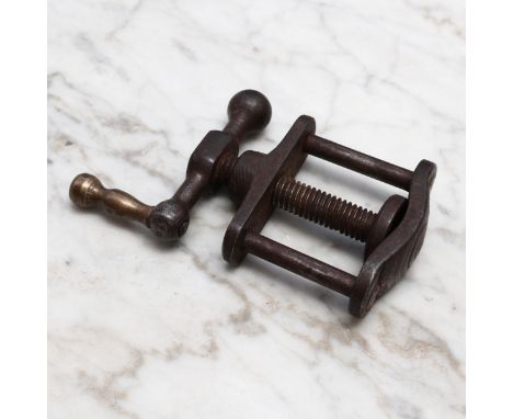 Nutcrackers - a 19th century iron table screw nut cracker, turned brass handle, the worm flanked by two plain pillars, 10cm l