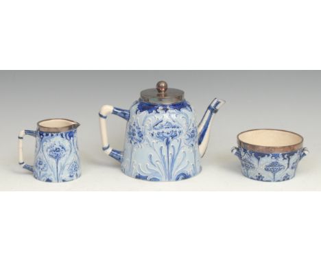 A Moorcroft McIntyre Florian three piece tea service, designed by William Moorcroft, tube lined with sinuous stems and flower