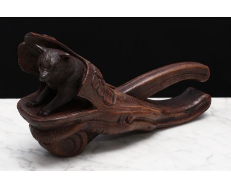 Nutcrackers - a Black Forest novelty lever-action nut cracker, carved as a bear emerging from a tree trunk, 20.5cm long, earl