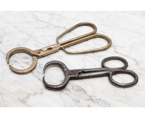Nutcrackers - an 18th/19th century brass pincer-form nut cracker, loop handles, copper rivet, 19.5cm long; another, steel (2)