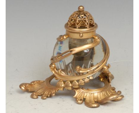 A 19th century French gilt metal and clear glass inkwell, pierced and embossed in the Rococo taste, 11cm high, c.1890 