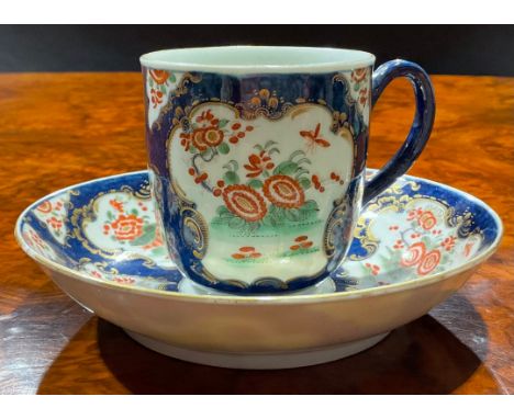 A Worcester coffee cup and saucer, decorated with alternating fan and vase shaped reserves, each with flowers and foliage, on