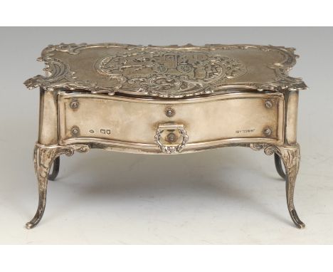 A late Victorian silver novelty dressing table top jewellery cabinet, inspired by a Louis XV serpentine commode, embossed wit