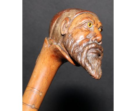 A 19th century walking stick or cane, the pommel carved as the head of a bearded man, wearing a fez, 84.5cm long 