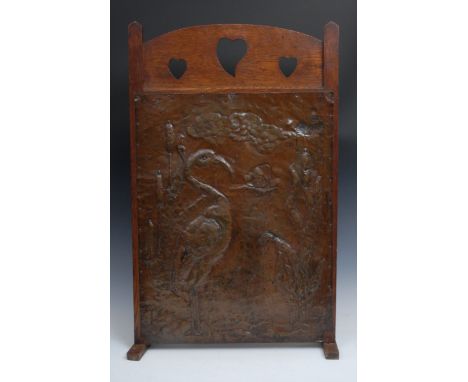 An Arts and Crafts beaten copper and oak rectangular fire screen, arched cresting pierced with heart shaped motifs, the banne