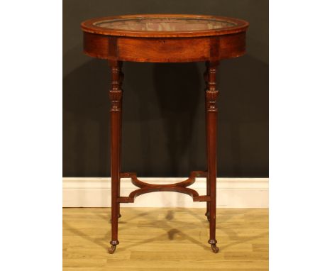 A late Victorian/Edwardian mahogany oval bijouterie table, hinged top, cylindrical legs, shaped X-stretcher, ceramic casters,