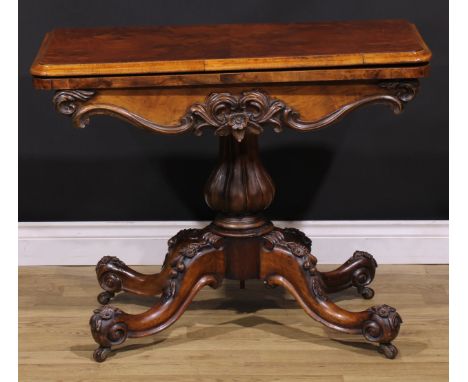 A Victorian walnut card table, hinged top enclosing a baize lined playing surface, shaped frieze carved and applied with a fl