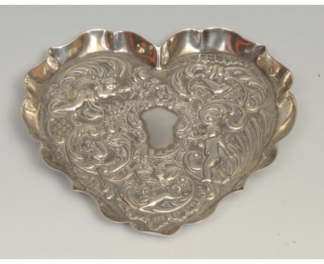 An Edwardian silver heart shaped dressing table trinket tray, chased with putti, birds and a squirrel amongst scrolls and fol